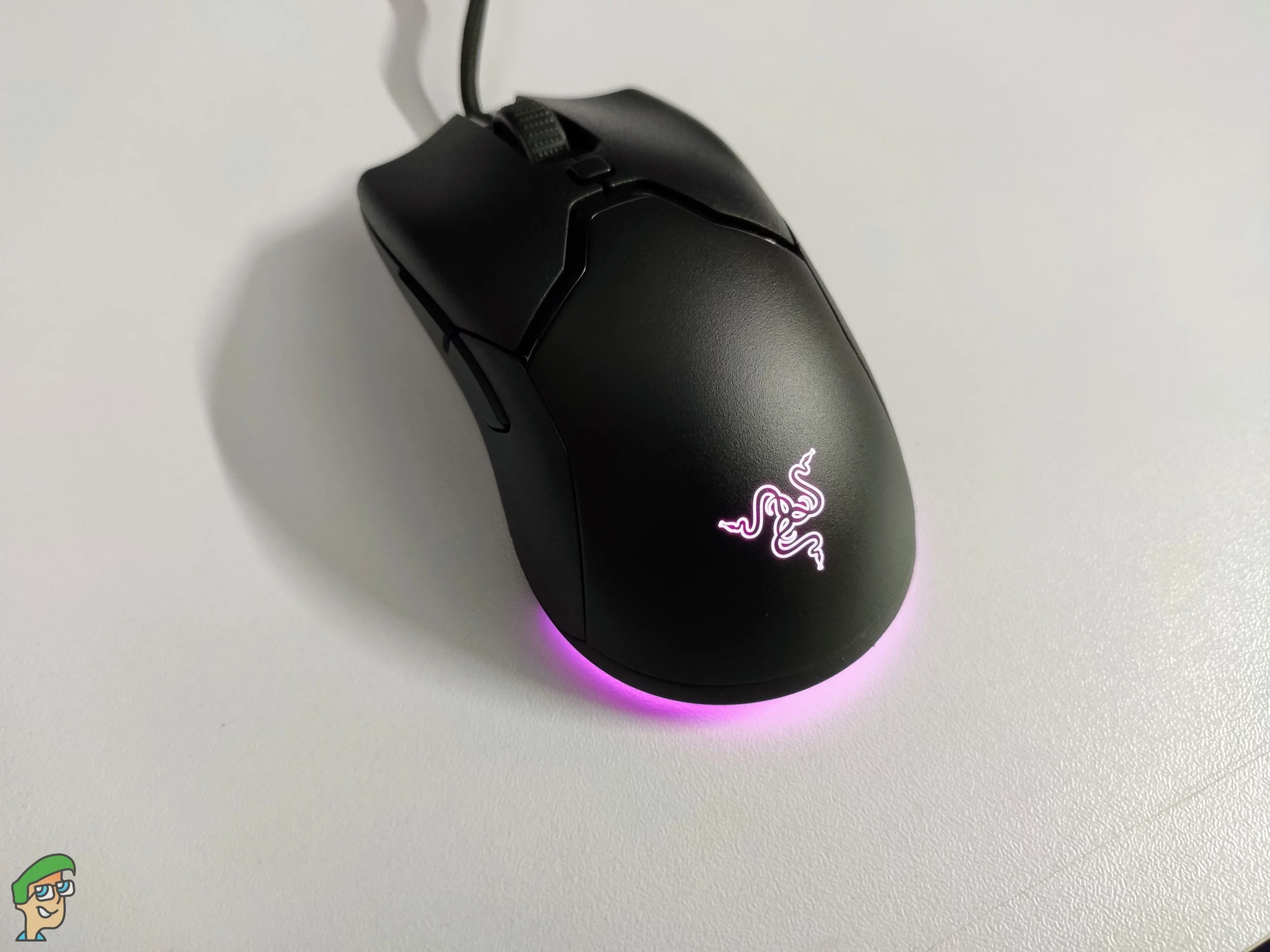 demonstration of Razer Viper Mini gaming mouse with purple rgb lighting on a white desk